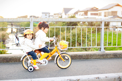 自転車に二人乗りする姉妹